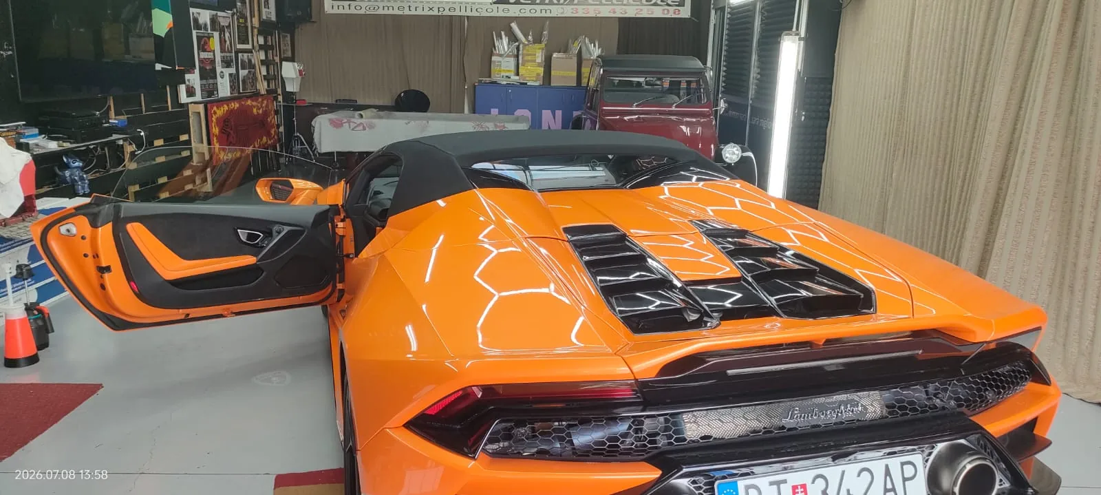 Dettaglio del posteriore di una Lamborghini Huracan arancione nel laboratorio Metrix