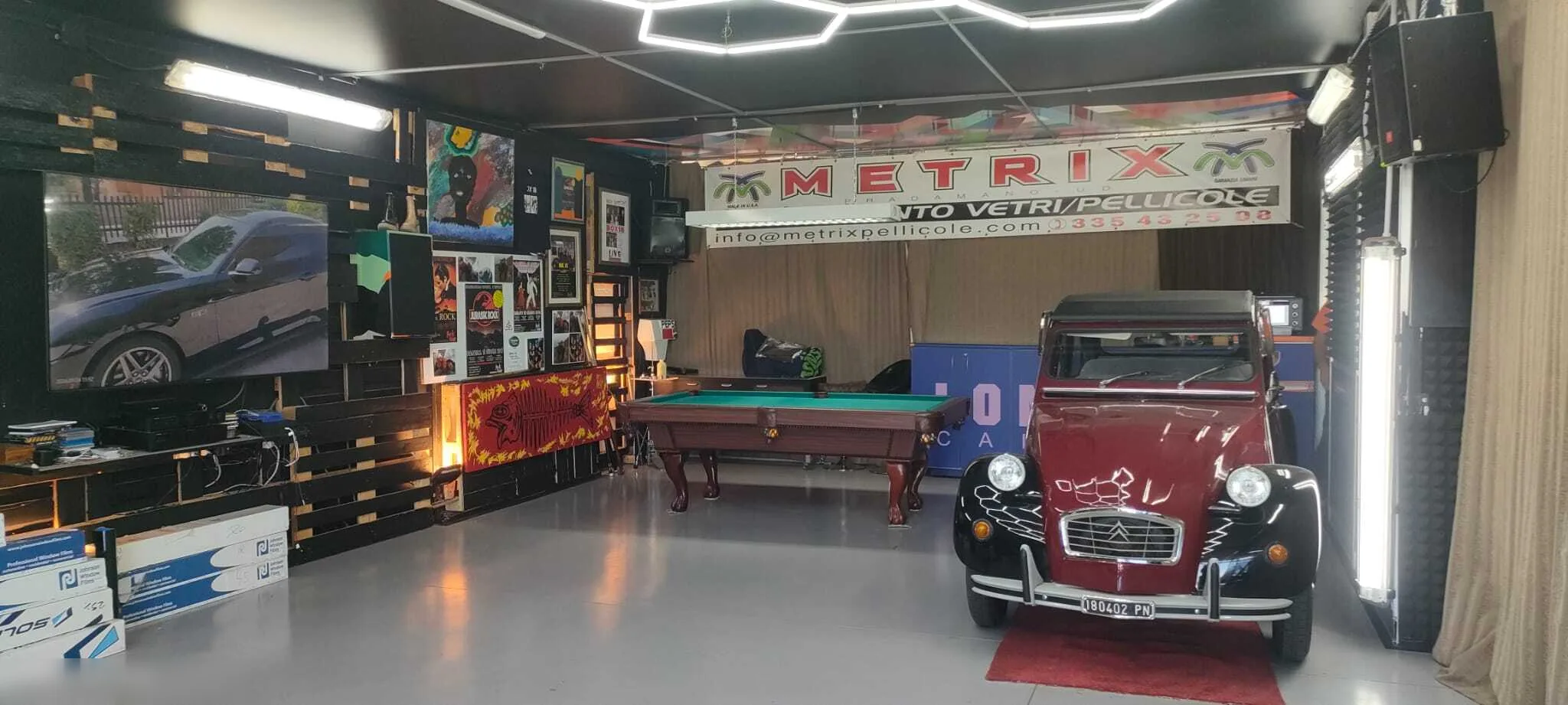 Sala del laboratorio Metrix con insegna, biliardo e auto d'epoca