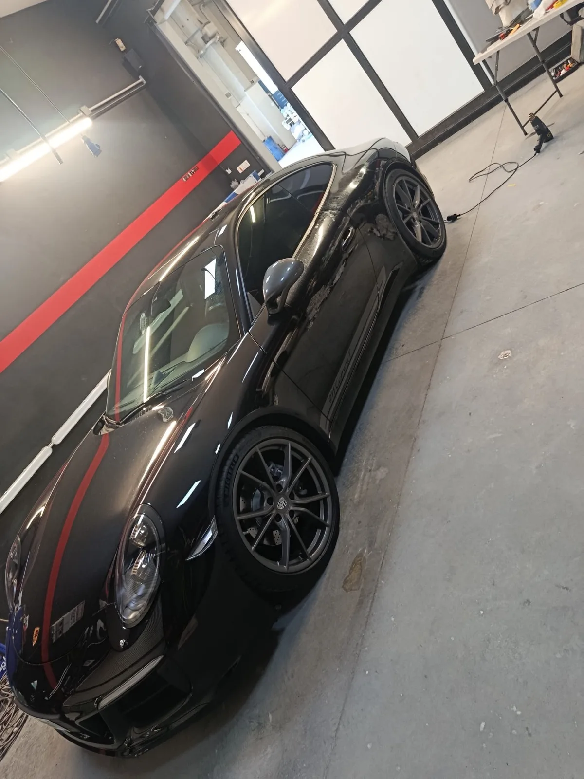 Porsche 911 nera con vetri oscurati nel laboratorio Metrix, vista laterale