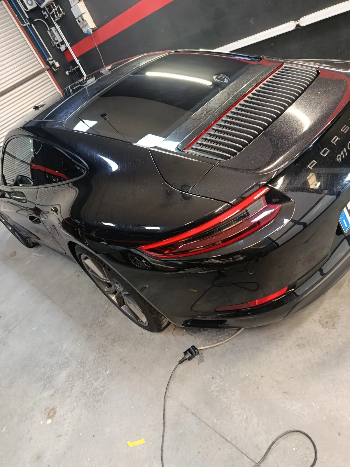 Dettaglio del posteriore di una Porsche 911 nera con vetri oscurati
