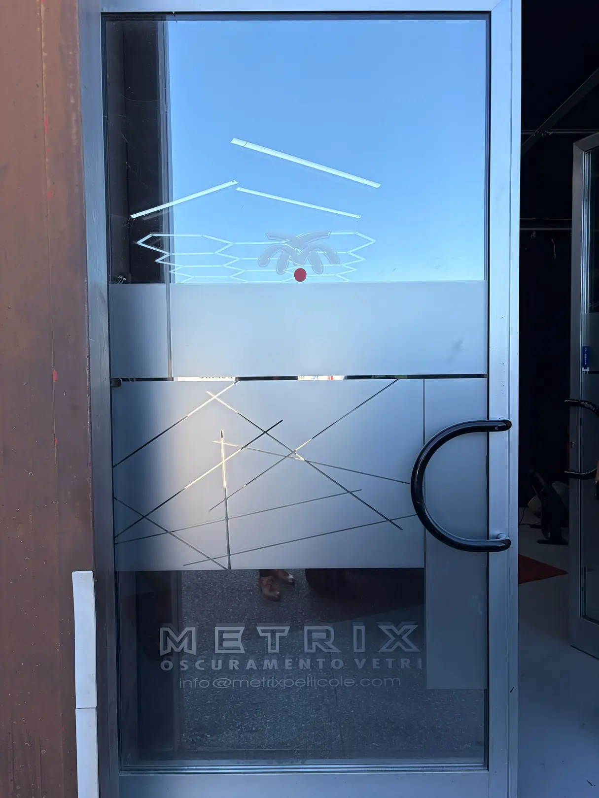 Vetrofania decorativa sulla porta d'ingresso di Metrix